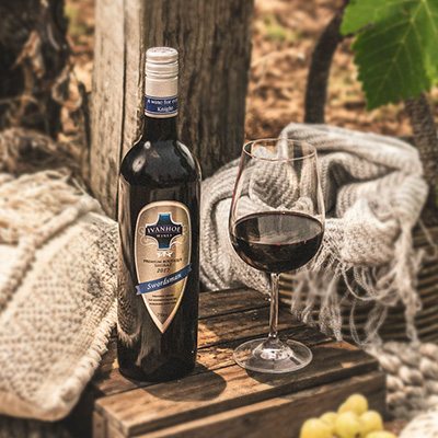 A bottle of Ivanhoe 2017 Swordsman Shiraz beside a glass in the vineyard