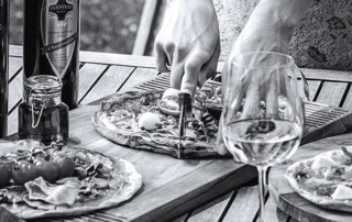 Ivanhoe wines with person cutting homemade pizzas